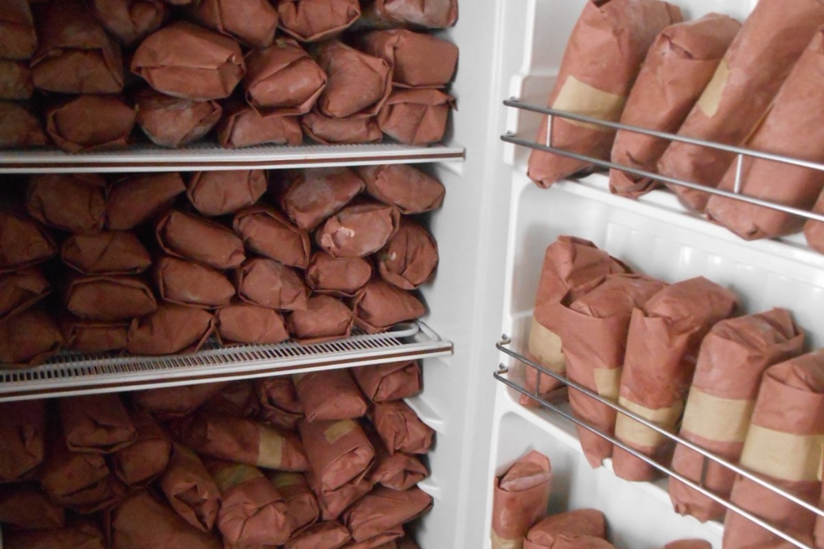 A home chest freezer fully stocked with butcher-paper-wrapped cuts of Whole Cow Texas beef
