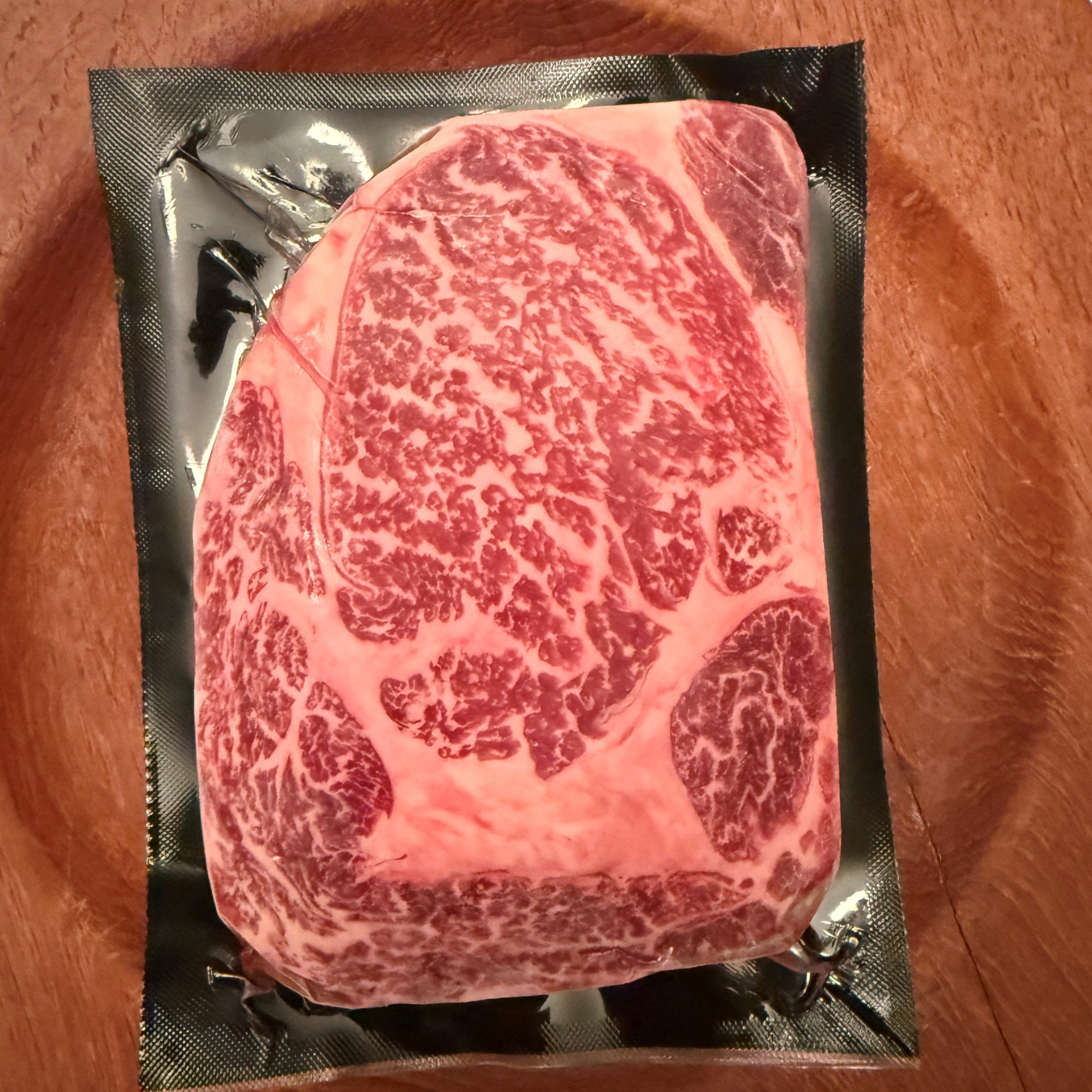 A premium, flash-frozen 100% Fullblood American Wagyu ribeye steak cleanly vacuum-sealed in heavy-duty commercial packaging by Whole Cow.