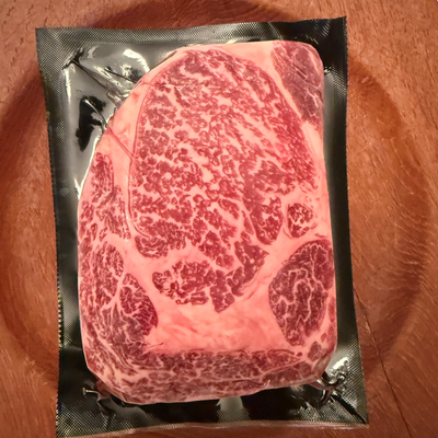 A premium, flash-frozen 100% Fullblood American Wagyu ribeye steak cleanly vacuum-sealed in heavy-duty commercial packaging by Whole Cow.